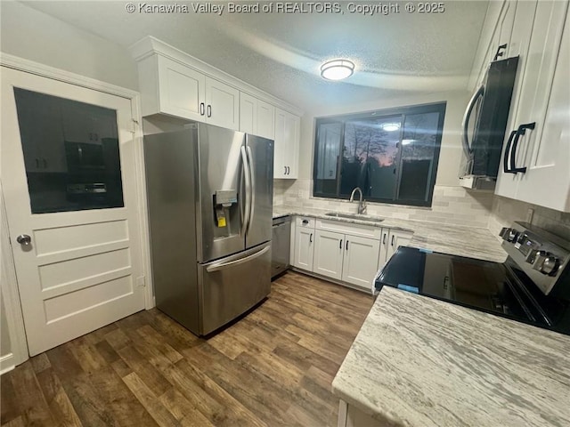 5218 Walnut Valley Dr, Charleston, WV 25313 - kitchen featuring appliances with stainless steel finishes, a sink, decorative backsplash, white cabinetry, and light stone countertops