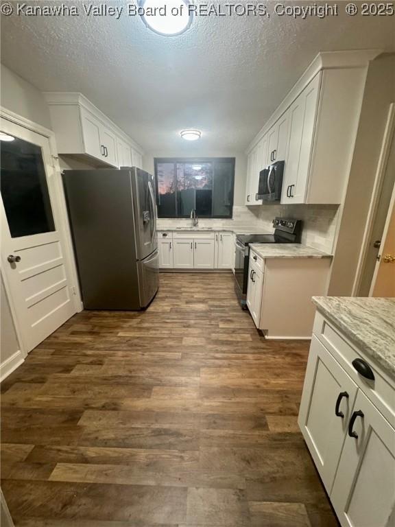 5218 Walnut Valley Dr, Charleston, WV 25313 - kitchen with appliances with stainless steel finishes, a sink, white cabinetry, dark wood finished floors, and a textured ceiling