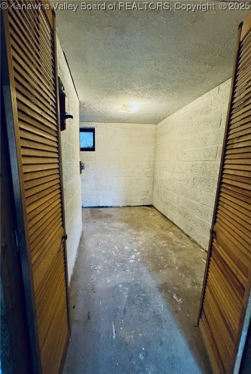 5218 Walnut Valley Dr, Charleston, WV 25313 - unfurnished room with concrete floors, concrete block wall, and a textured ceiling