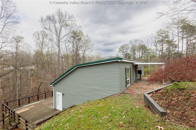 view of home's exterior with a wooden deck and a patio