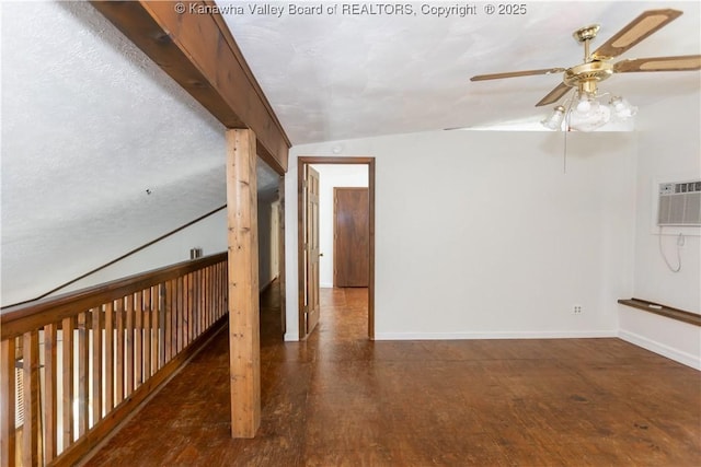 interior space with baseboards, a wall mounted air conditioner, ceiling fan, wood finished floors, and lofted ceiling