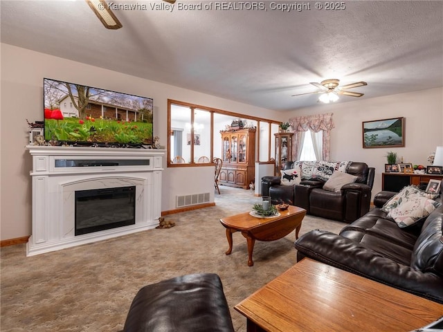 139 Betty Ln, Scott Depot, WV 25560 - carpeted living area featuring a glass covered fireplace, visible vents, baseboards, and a ceiling fan