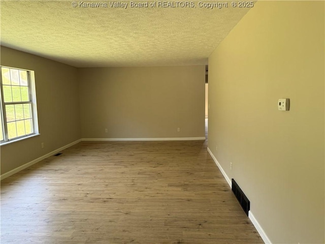 1651 Glenwood Rd, Milton, WV 25541 - spare room with a textured ceiling, baseboards, visible vents, and wood finished floors