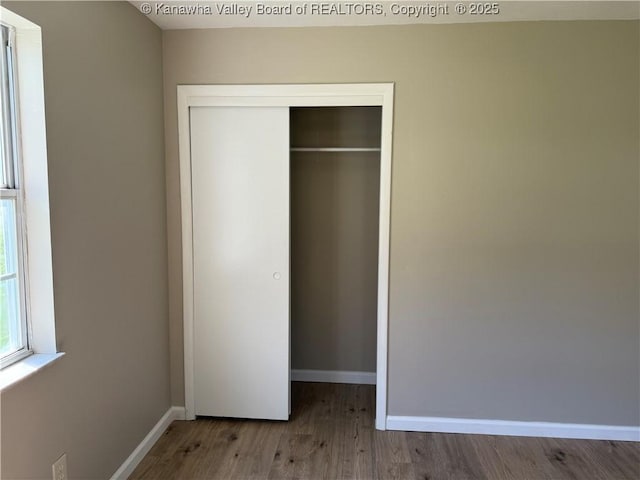 1651 Glenwood Rd, Milton, WV 25541 - unfurnished bedroom with baseboards, a closet, and wood finished floors