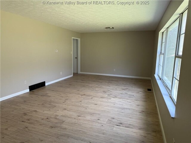 1651 Glenwood Rd, Milton, WV 25541 - spare room featuring a textured ceiling, wood finished floors, and baseboards