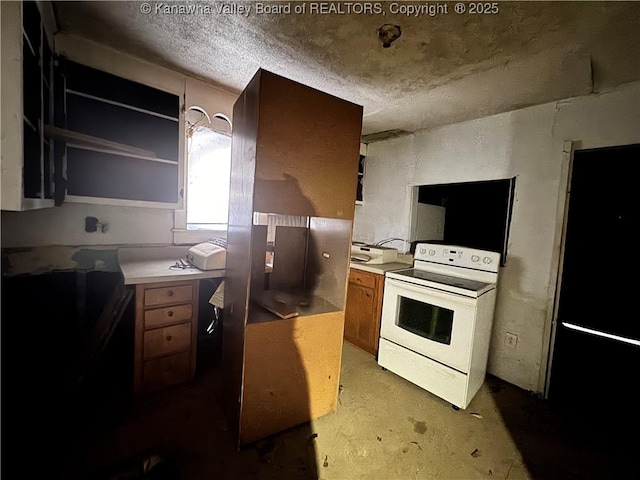 5806 Kanawha State Forest Dr, Charleston, WV 25314 - kitchen with brown cabinets, white range with electric cooktop, freestanding refrigerator, and a textured ceiling