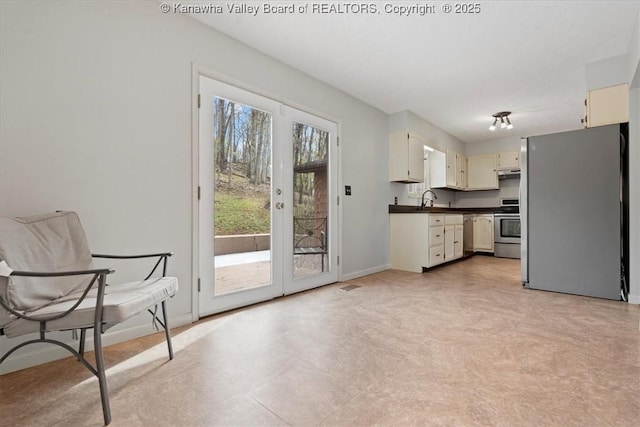 141 Wedgewood Rd, Ravenswood, WV 26164 - kitchen featuring under cabinet range hood, dark countertops, a sink, stainless steel appliances, and baseboards