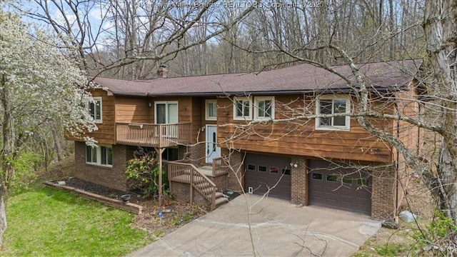 141 Wedgewood Rd, Ravenswood, WV 26164 - split foyer home with an attached garage, a chimney, concrete driveway, stairs, and brick siding