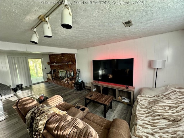 109 Cedar Ln, Saint Albans, WV 25177 - living room featuring a brick fireplace, wood finished floors, a textured ceiling, and visible vents
