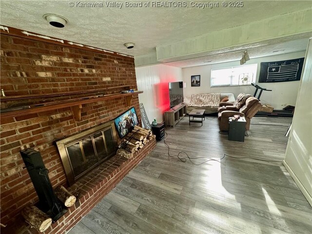 109 Cedar Ln, Saint Albans, WV 25177 - living area with wood finished floors, a brick fireplace, and a textured ceiling