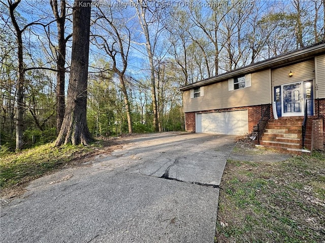 109 Cedar Ln, Saint Albans, WV 25177 - view of side of home with an attached garage, brick siding, aphalt driveway, and entry steps