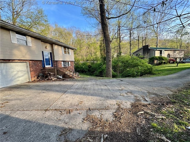 109 Cedar Ln, Saint Albans, WV 25177 - view of home's exterior with brick siding, an attached garage, and concrete driveway
