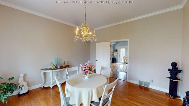 83 Lakeview Dr, Nitro, WV 25143 - dining room featuring wood-type flooring, an inviting chandelier, ornamental molding, and visible vents