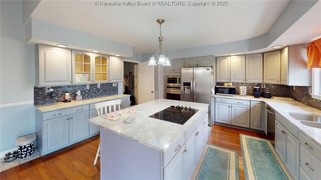 83 Lakeview Dr, Nitro, WV 25143 - kitchen with tasteful backsplash, wood finished floors, pendant lighting, appliances with stainless steel finishes, and a kitchen island