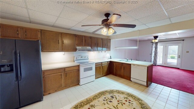 83 Lakeview Dr, Nitro, WV 25143 - kitchen with light carpet, white appliances, exhaust hood, ceiling fan, and brown cabinetry