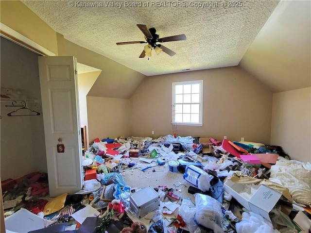 unfurnished bedroom with lofted ceiling, a textured ceiling, and ceiling fan