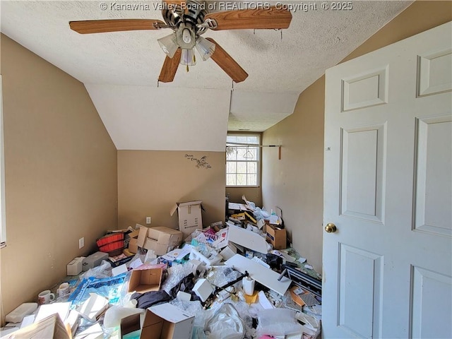 interior space featuring ceiling fan, lofted ceiling, and a textured ceiling