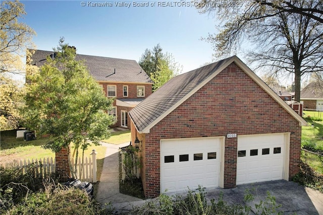 1055 Highland Dr, Saint Albans, WV 25177 - view of home's exterior with aphalt driveway, brick siding, roof with shingles, and a garage