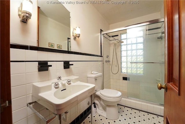1055 Highland Dr, Saint Albans, WV 25177 - full bathroom featuring a sink, tile patterned floors, a stall shower, tile walls, and toilet