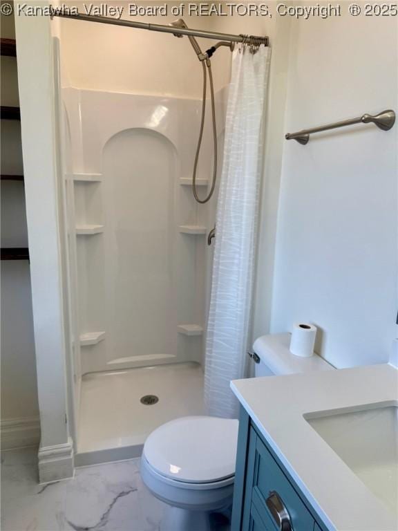 bathroom with marble finish floor, toilet, vanity, and a stall shower