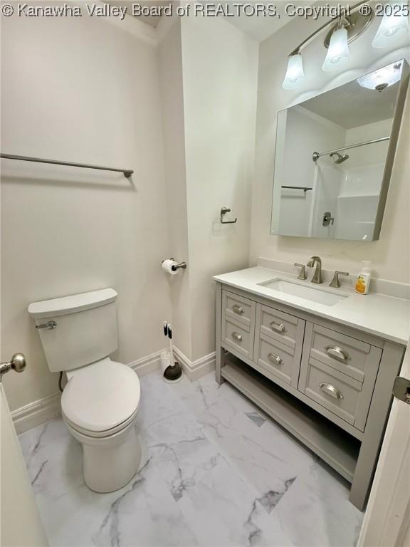 full bath featuring marble finish floor, baseboards, toilet, and vanity