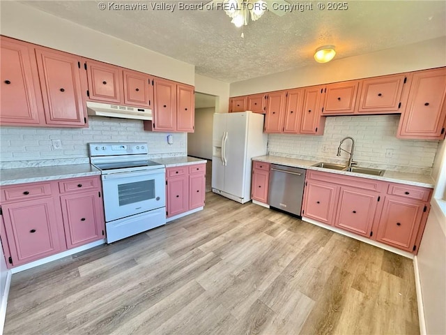 kitchen featuring a sink, light wood-style floors, white appliances, light countertops, and under cabinet range hood