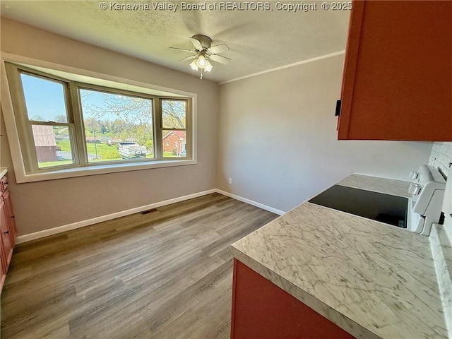 unfurnished dining area featuring baseboards, a ceiling fan, visible vents, and a textured ceiling