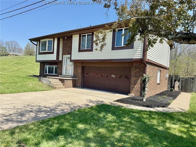 raised ranch with a front lawn, driveway, brick siding, and a garage