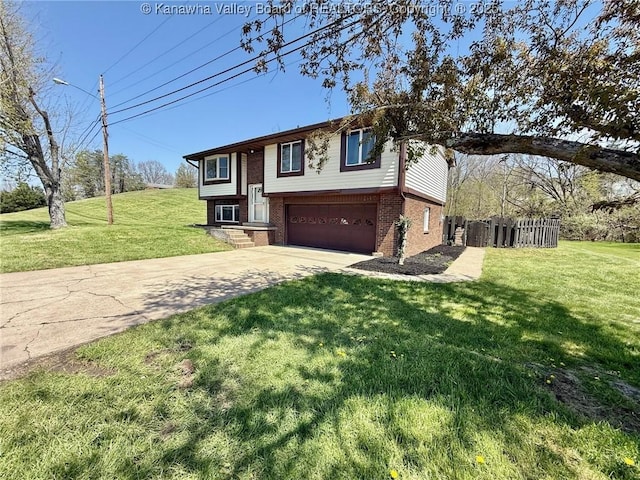 bi-level home featuring fence, driveway, brick siding, a front yard, and a garage