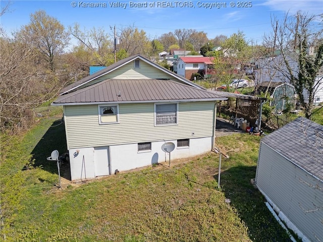 view of property exterior with a yard and metal roof