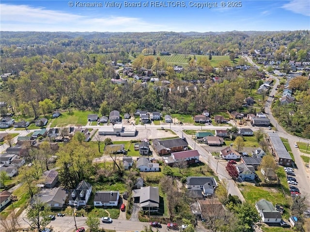 drone / aerial view featuring a view of trees and a residential view