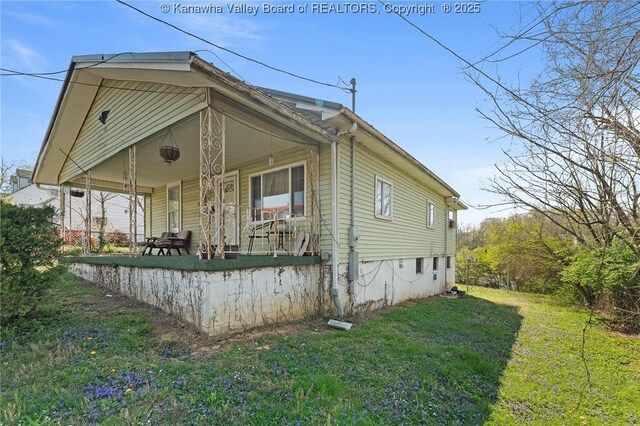 view of property exterior featuring a lawn and covered porch
