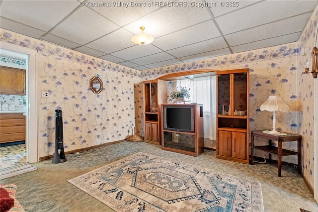 carpeted living room featuring wallpapered walls and a paneled ceiling
