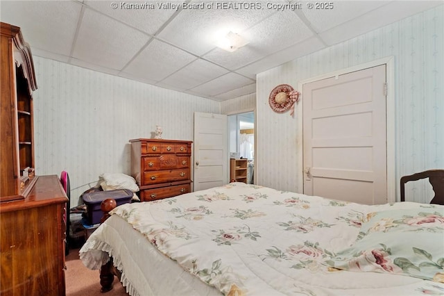 carpeted bedroom featuring wallpapered walls and a paneled ceiling