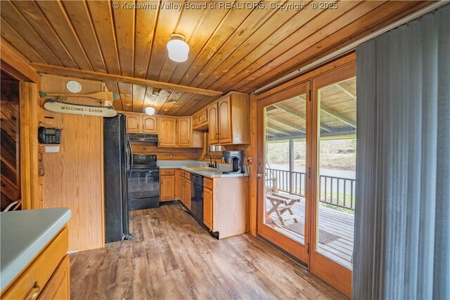 kitchen featuring black appliances, light wood finished floors, light countertops, wooden ceiling, and under cabinet range hood