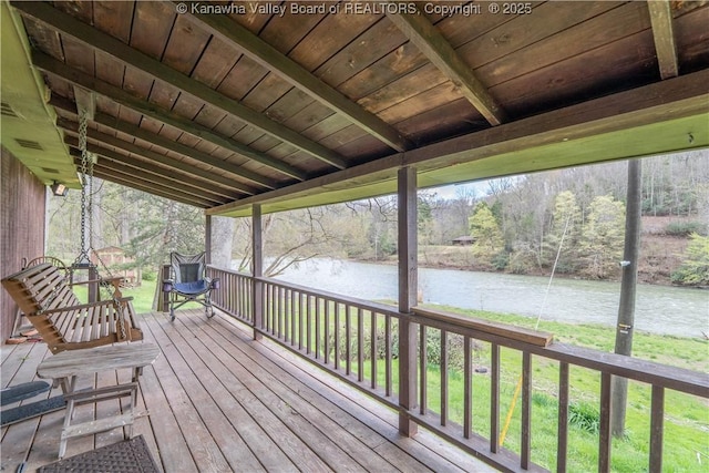 wooden deck with a yard and a water view