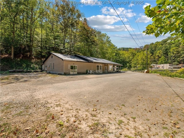 view of property exterior with a wooded view