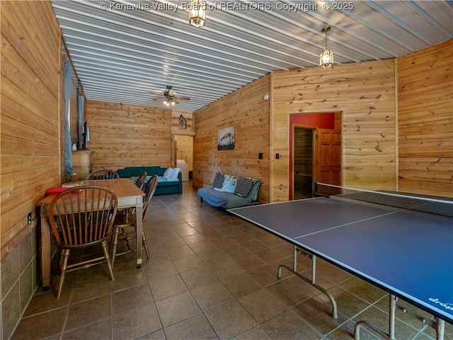 playroom with wood walls and a ceiling fan
