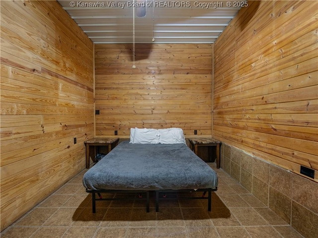 bedroom featuring wooden walls