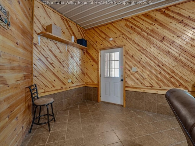 doorway to outside featuring wooden walls and tile patterned flooring
