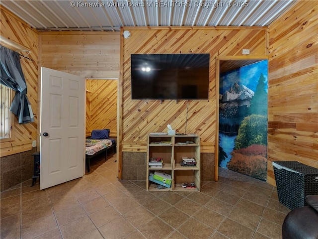 interior space with wooden walls and dark tile patterned floors