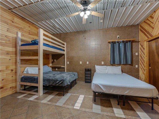 bedroom with tile walls, tile patterned floors, and wood walls