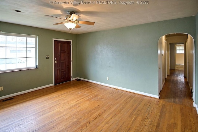 455 Kane St, Milton, WV 25541 - empty room featuring arched walkways, plenty of natural light, visible vents, ceiling fan, and hardwood / wood-style flooring