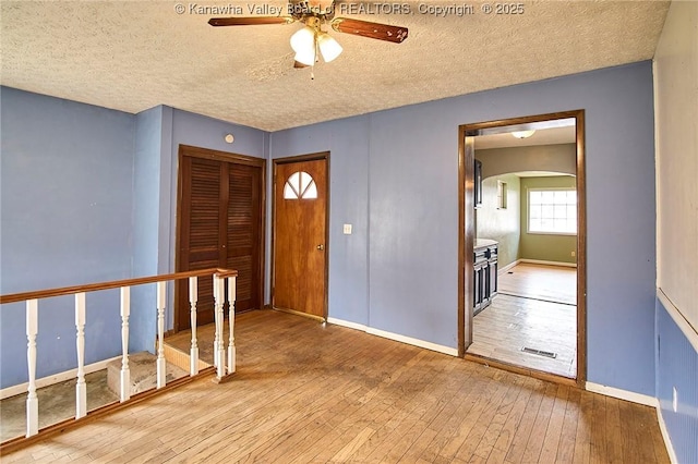 455 Kane St, Milton, WV 25541 - foyer entrance with wood-type flooring, arched walkways, a ceiling fan, and a textured ceiling