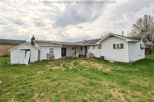 455 Kane St, Milton, WV 25541 - rear view of house with an outdoor structure, a storage unit, and a lawn
