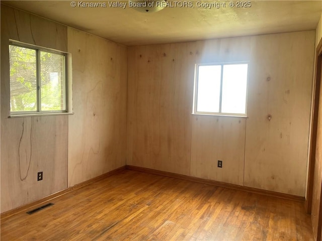 spare room featuring light wood-type flooring and visible vents