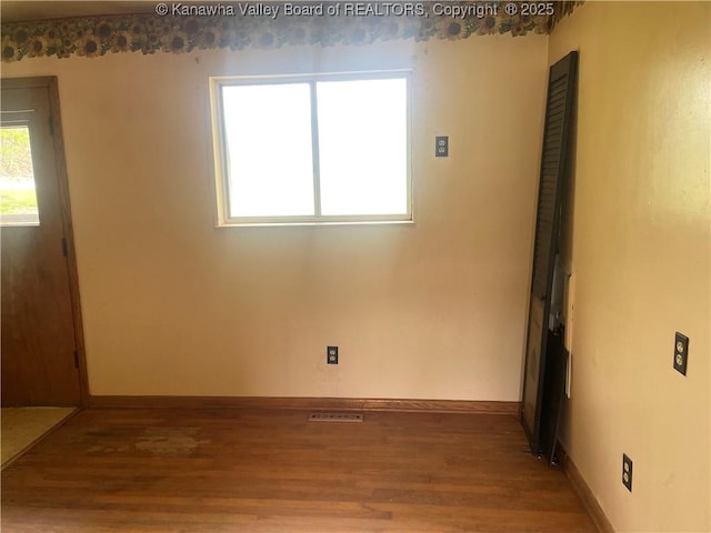 empty room featuring baseboards and wood finished floors