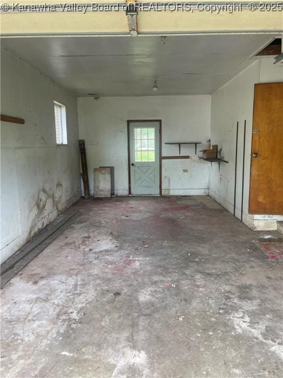 interior space with unfinished concrete flooring and a healthy amount of sunlight
