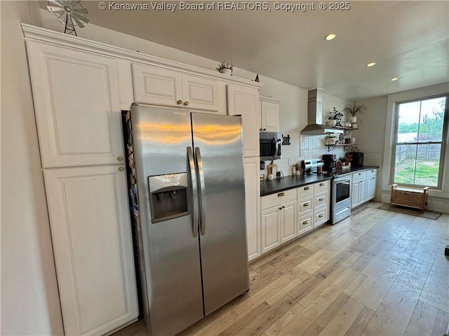 2206 Jefferson Ave, Point Pleasant, WV 25550 - kitchen with wall chimney range hood, dark countertops, decorative backsplash, light wood-style floors, and appliances with stainless steel finishes