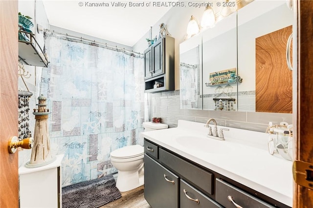 full bathroom featuring toilet, tile walls, decorative backsplash, curtained shower, and vanity